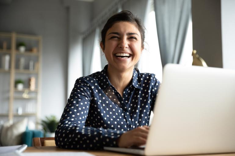 Mujer sonriendo frente a un computador